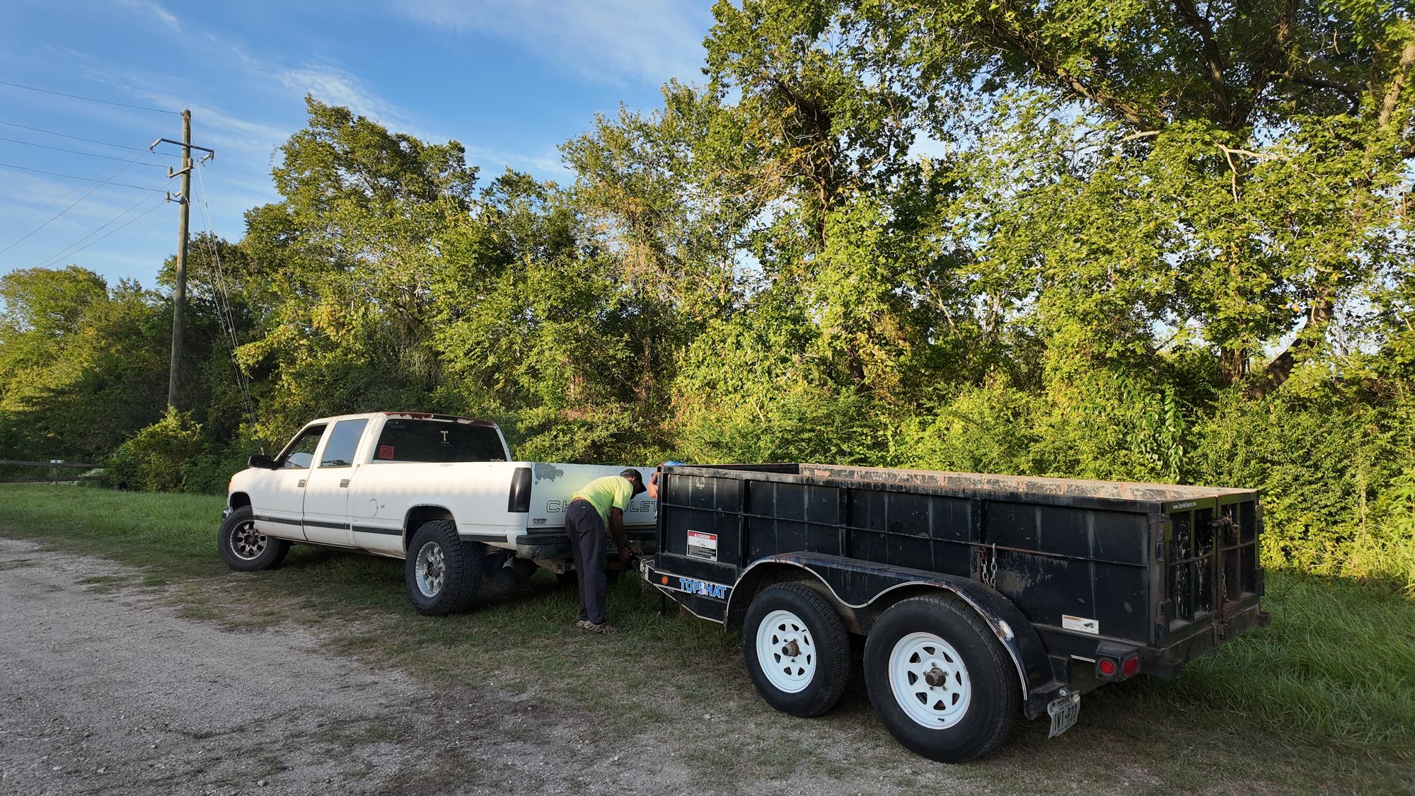 The TTTT Junk Removal truck hitched to the loaded dump trailer, ready for a Houston-area job